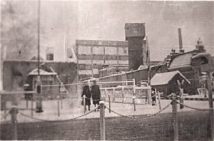 httpsLage-Bothofstraat-5-Textielfabriek-Nico-ter-Kuile-gezien-vanaf-Oldenzaalsestraat-met-spoorwegovergang-22-2-1944-300x198